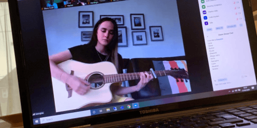 Student playing guitar online