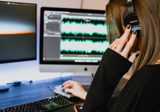 Teenage girl with headphones on using music composition software on a computer. Image by Kelly Sikkema on Unsplash