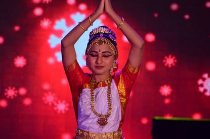 Girl dancing with hands pressed together above her head